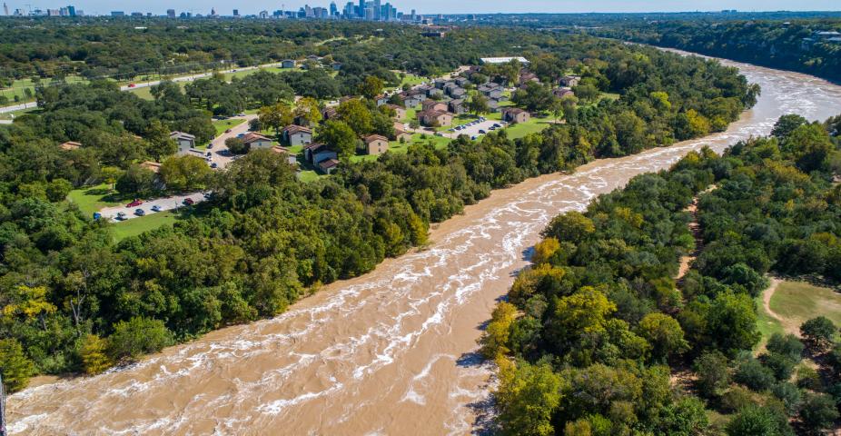 Austin Flooding aerial drone view from high above Colorado River and Red Bud Isle Flood waters with Austin , Texas skyline in the far distance