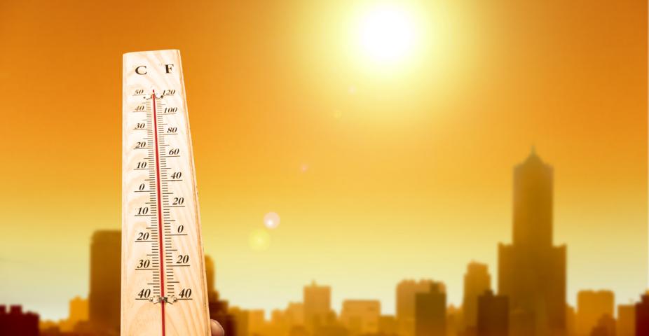 heat wave in the city and hand showing thermometer for high temperature