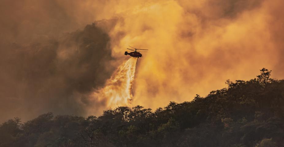 Helicopter doing a water drop on a wildfire