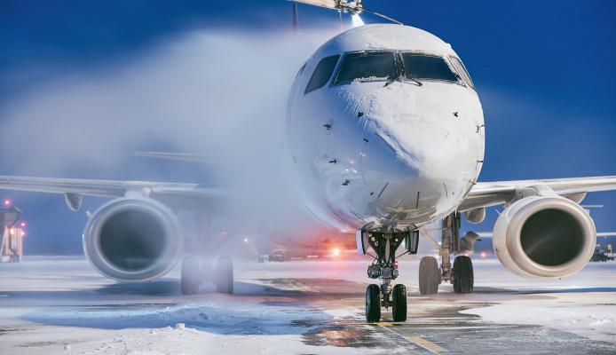 Winter morning at airport. Deicing of airplane before flight.