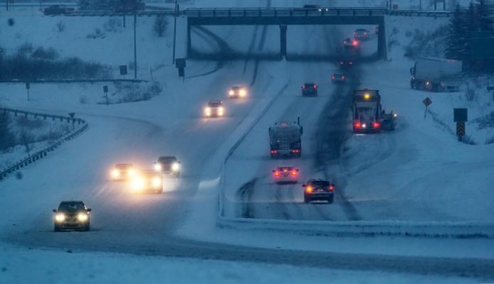Heavy snow falls on a multi-lane highway interchange