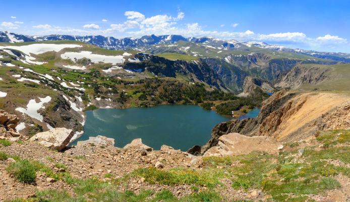 Alpine lake and snowy mountain in high altitude near Yellowstone National Park in Wyoming, off of Beartooth Highway between Red Lodge and Yellowstone National Park.