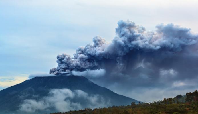 Mount Agung erupting plume. During volcano eruption thousands of people was evacuated from dangerous zone because of the threat of explosive eruption and the danger of pyroclastic flows. Airline flights to Bali were canceled, Denpasar airport closed because of volcanic ash clouds in the air.