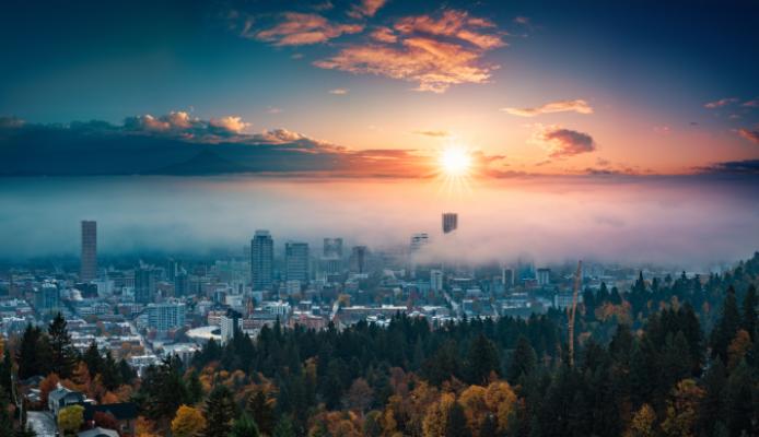 A photograph of Portland downtown with rolling fog and autumn foliage in shining sunrise and colorful clouds