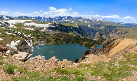 Alpine lake and snowy mountain in high altitude near Yellowstone National Park in Wyoming, off of Beartooth Highway between Red Lodge and Yellowstone National Park.