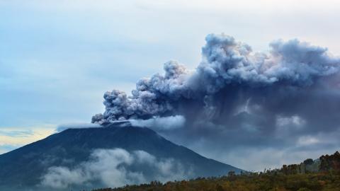 Mount Agung erupting plume. During volcano eruption thousands of people was evacuated from dangerous zone because of the threat of explosive eruption and the danger of pyroclastic flows. Airline flights to Bali were canceled, Denpasar airport closed because of volcanic ash clouds in the air.