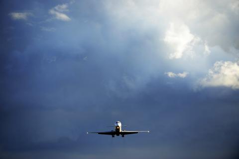 Front view of sunlit airplane landing in bad weather