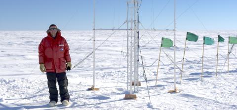 RAL Scientist, Scott Landolt, standing next to a precipitation guage in Antarctica (photo courtesy of Scott Landolt, https://icechaser.blogspot.com).