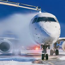 Winter morning at airport. Deicing of airplane before flight.