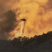 Helicopter dumping water on forest fire