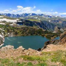 Alpine lake and snowy mountain in high altitude near Yellowstone National Park in Wyoming, off of Beartooth Highway between Red Lodge and Yellowstone National Park.
