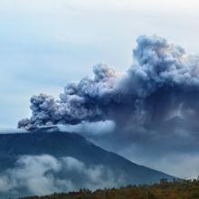 Mount Agung erupting plume. During volcano eruption thousands of people was evacuated from dangerous zone because of the threat of explosive eruption and the danger of pyroclastic flows. Airline flights to Bali were canceled, Denpasar airport closed because of volcanic ash clouds in the air.